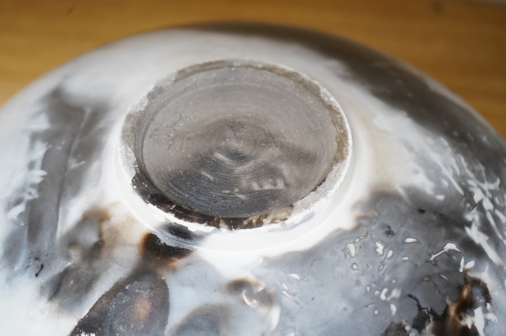 David Harrison (Modern British) a pit fired pottery vase of circular squat form, incised initials to the base, 31cm in diameter